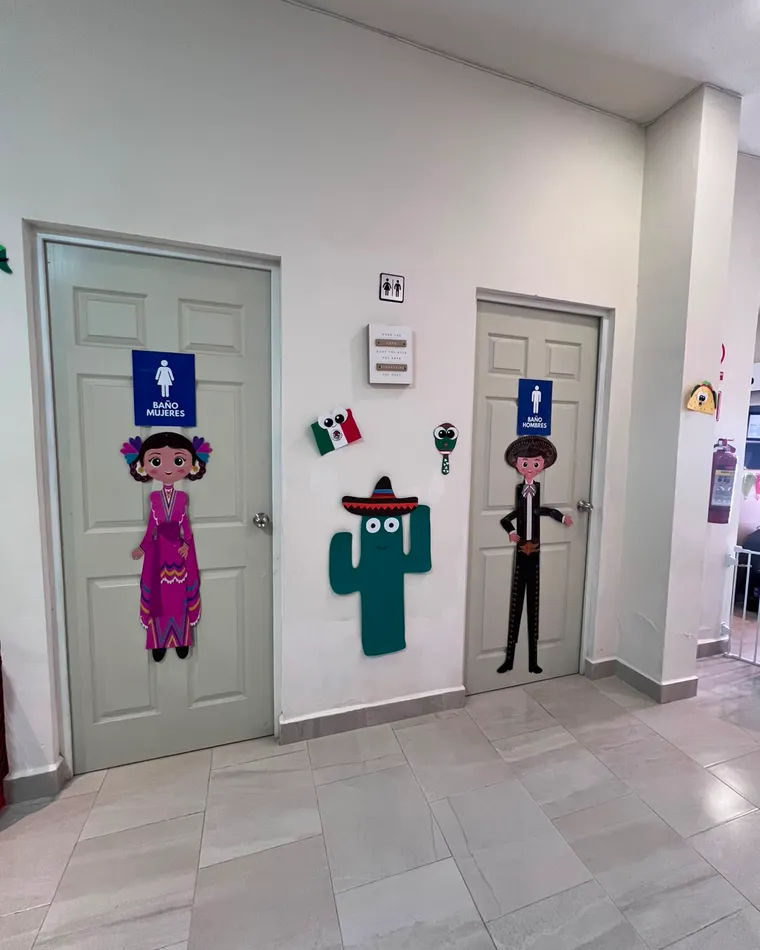 Puertas de los baños decoradas con personajes de colores.